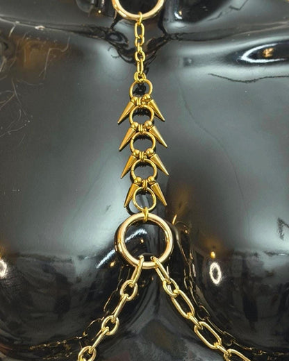 Gold close-up of spike ladder and rings, textured pointed connectors, dramatic gold spine harness detail