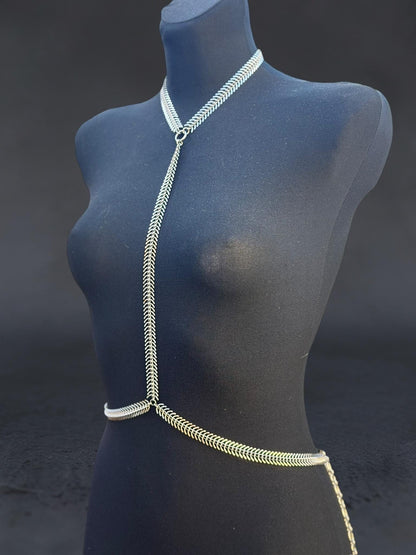 Angled blue mannequin displays spine body chain, minimalist stainless steel harness, Y-shaped neck and waist chain