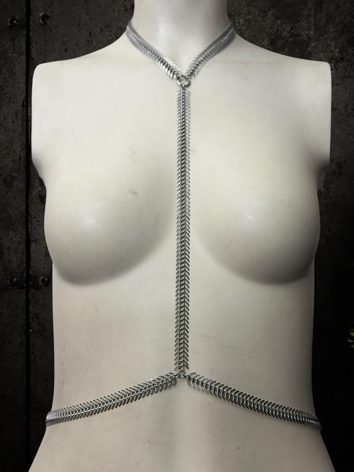 White mannequin frontal with spine body chain, skeletal Y silhouette in polished stainless steel gothic body jewelry