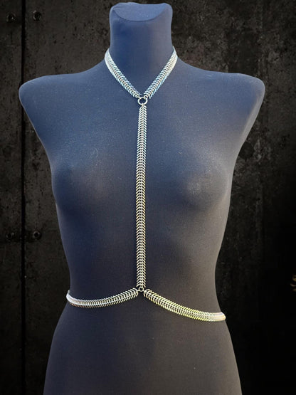 Blue mannequin lit from side, spine body chain neck loop and central column highlighted, stainless steel clubwear accessory