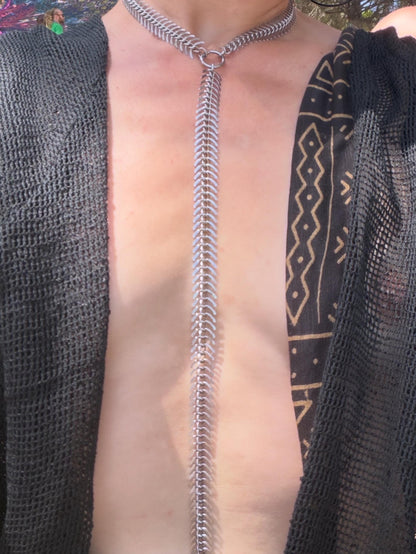 Close-up chest shot with spine body chain cascading down skin, polished stainless steel vertebrae chain, rave accessory