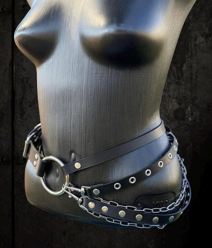 Side torso shot, layered cascade chain belt looping under hip, black faux-leather with silver hardware