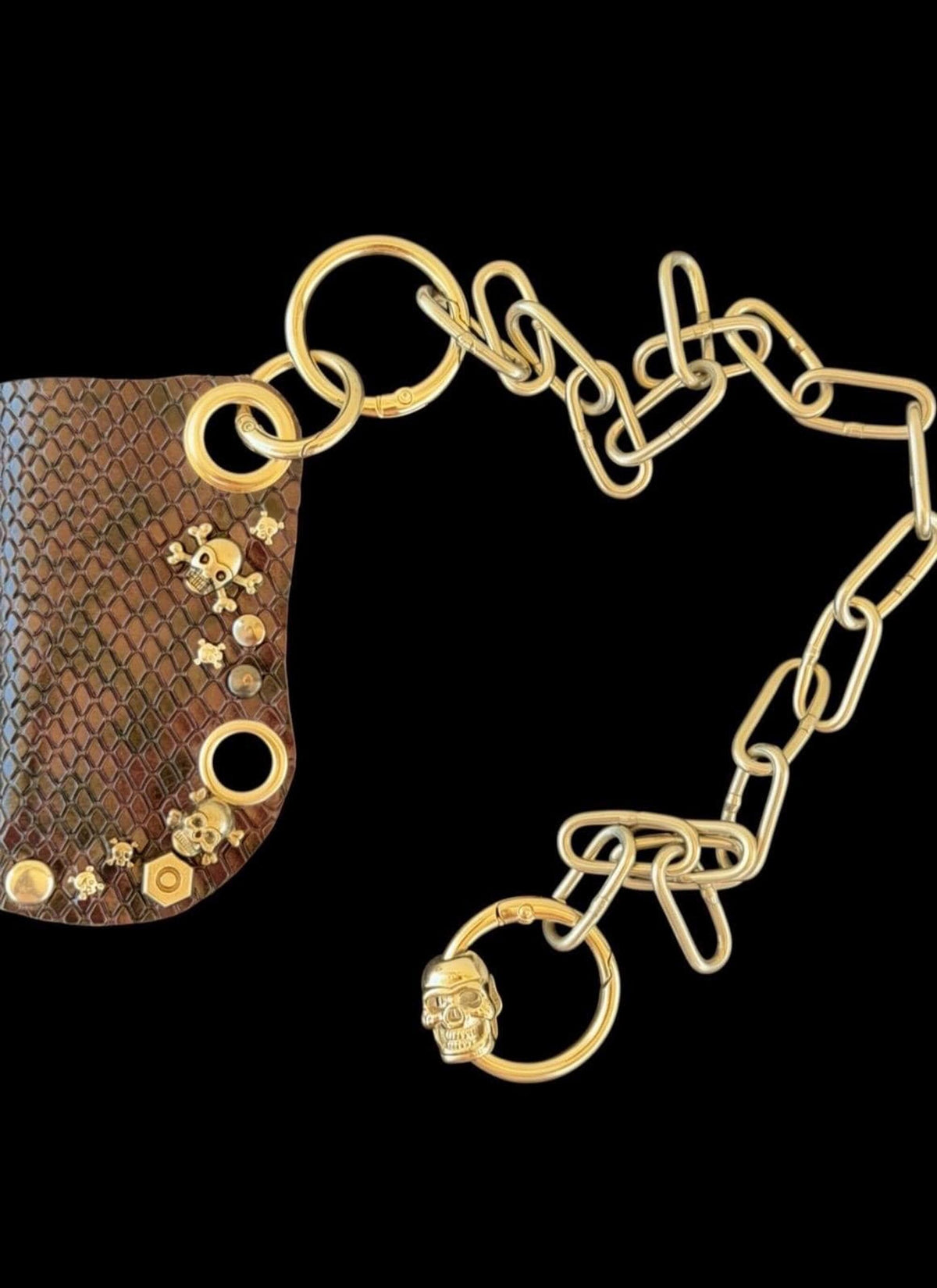 Gold detachable chain and assorted linking rings on black background, chain style option for leather lighter case with chain