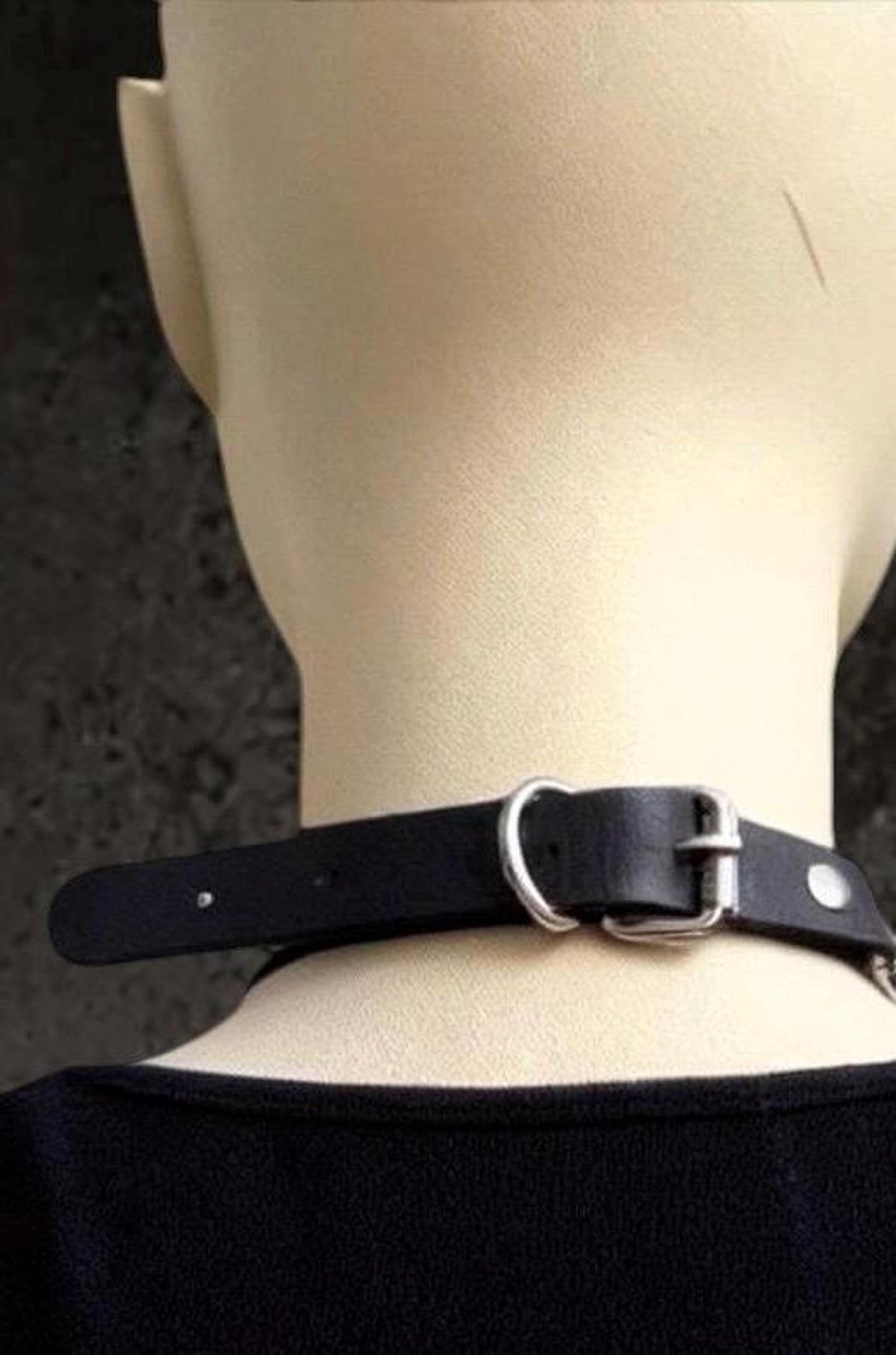 Back neck view shows adjustable black leather choker strap, silver buckle closure, pairs with stainless chain layers