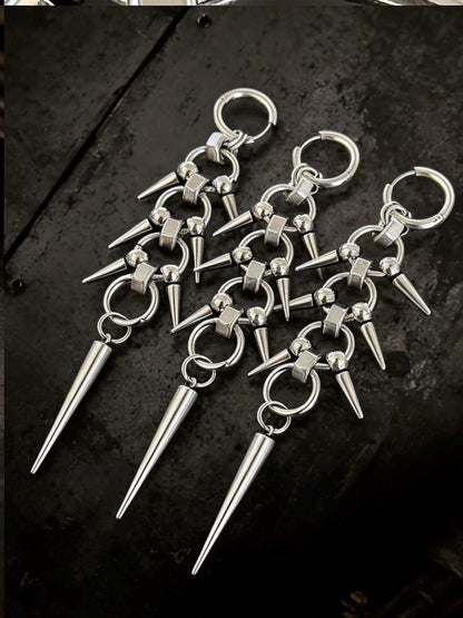 Three pairs fanned on dark backdrop, chainmail spike earrings highlighting silver-tone finish and elongated silhouette