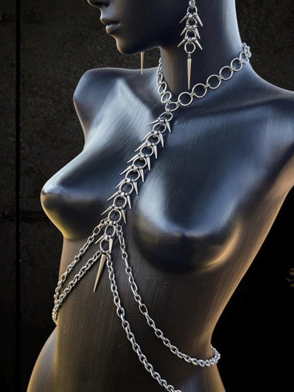 Torso mannequin styled with matching chain harness and a dangling spike, gothic spike dangle earrings as set piece