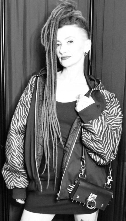 Editorial black and white portrait, alternative crossbody black spiked leather bag, harness details