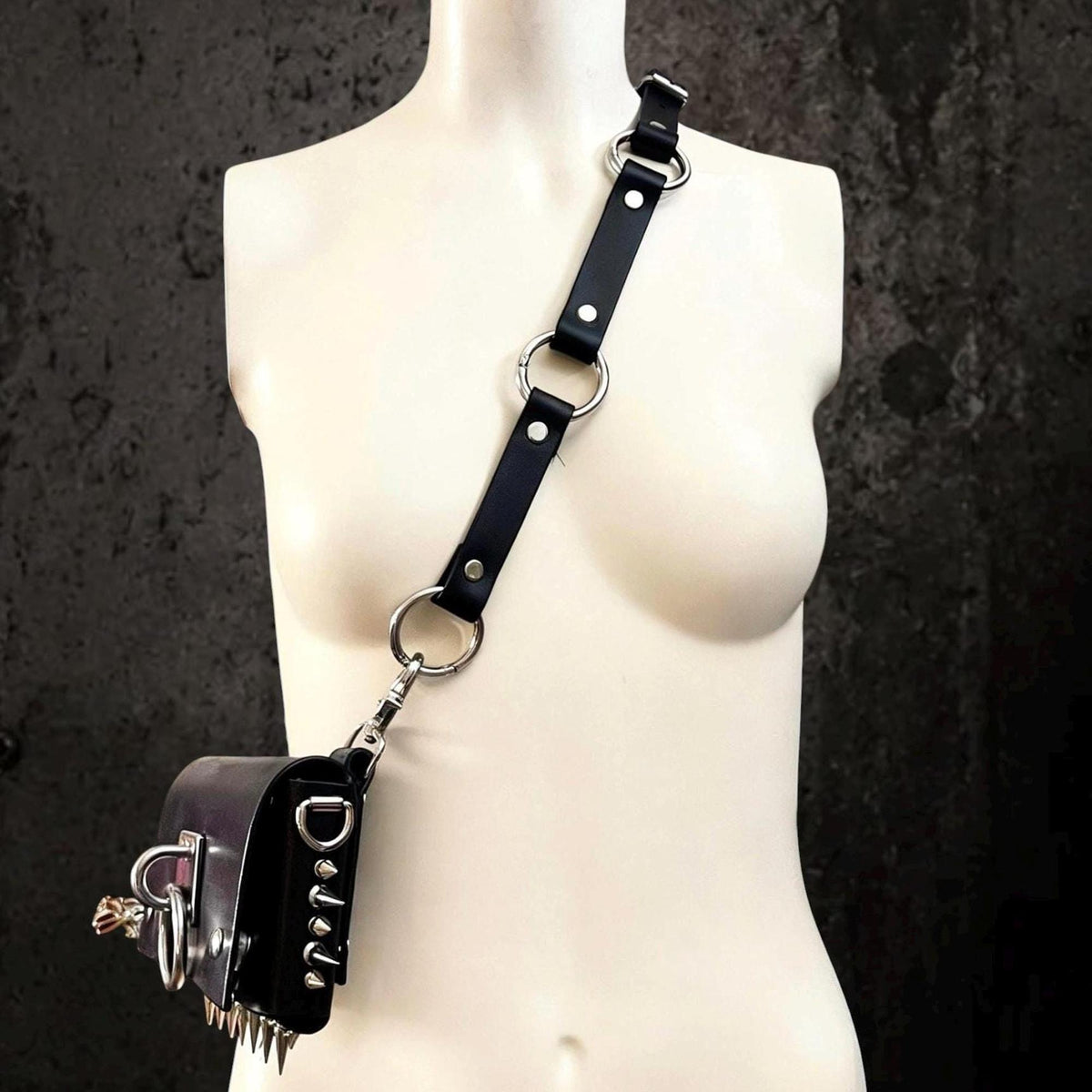 Single-shoulder bag strap variant, convertible leather harness clipped to a small leather pouch at hip