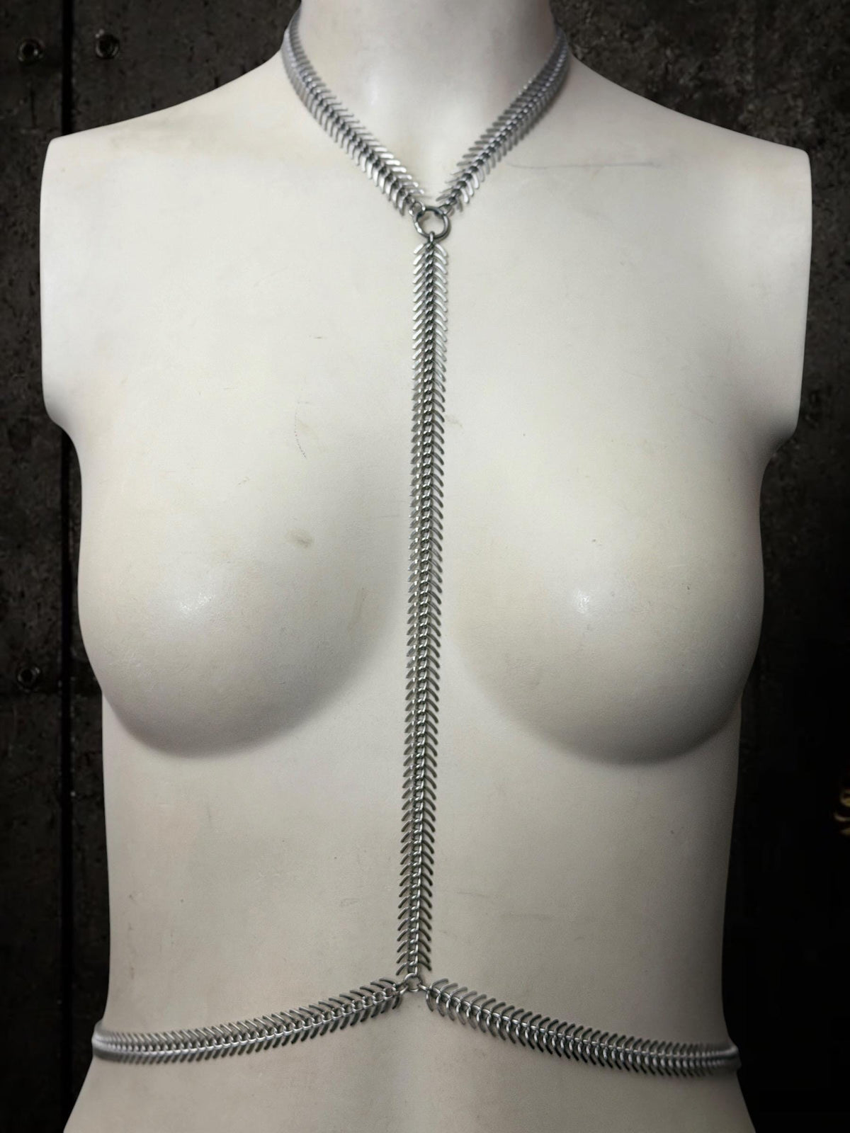 White mannequin with low waist loop, spine body chain runs down torso, adjustable stainless steel harness for clubwear