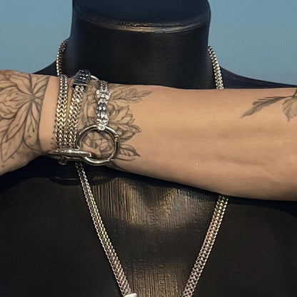 Wrist stack shows modular chains and ring used as bracelet, stainless steel punk festival jewelry on arm.