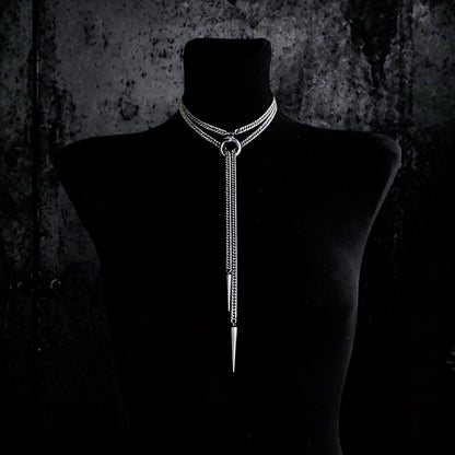 Centered black bust wearing Ouroboros choker necklace, layered curb chains, long tapered spike drop, stainless steel shine