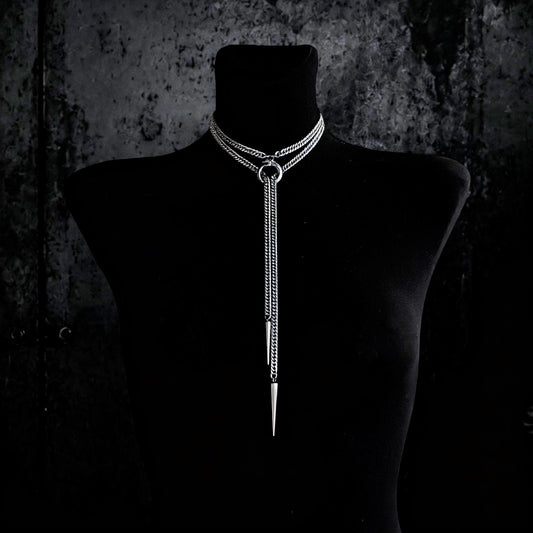 Centered black bust wearing Ouroboros choker necklace, layered curb chains, long tapered spike drop, stainless steel shine